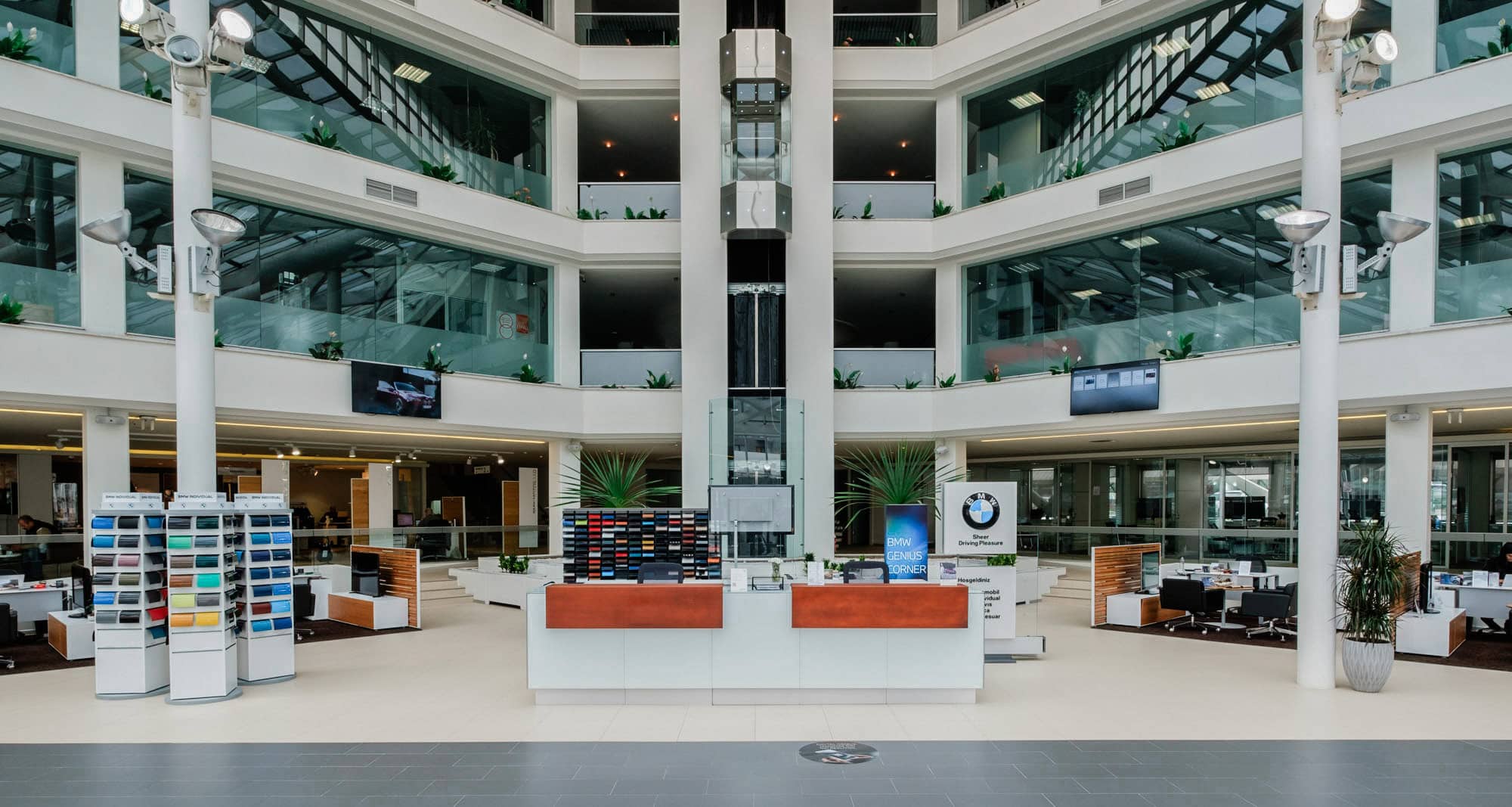 Interior circular de un concesionario BMW de varias plantas, vehículos en planta baja y galerías en los niveles superiores.