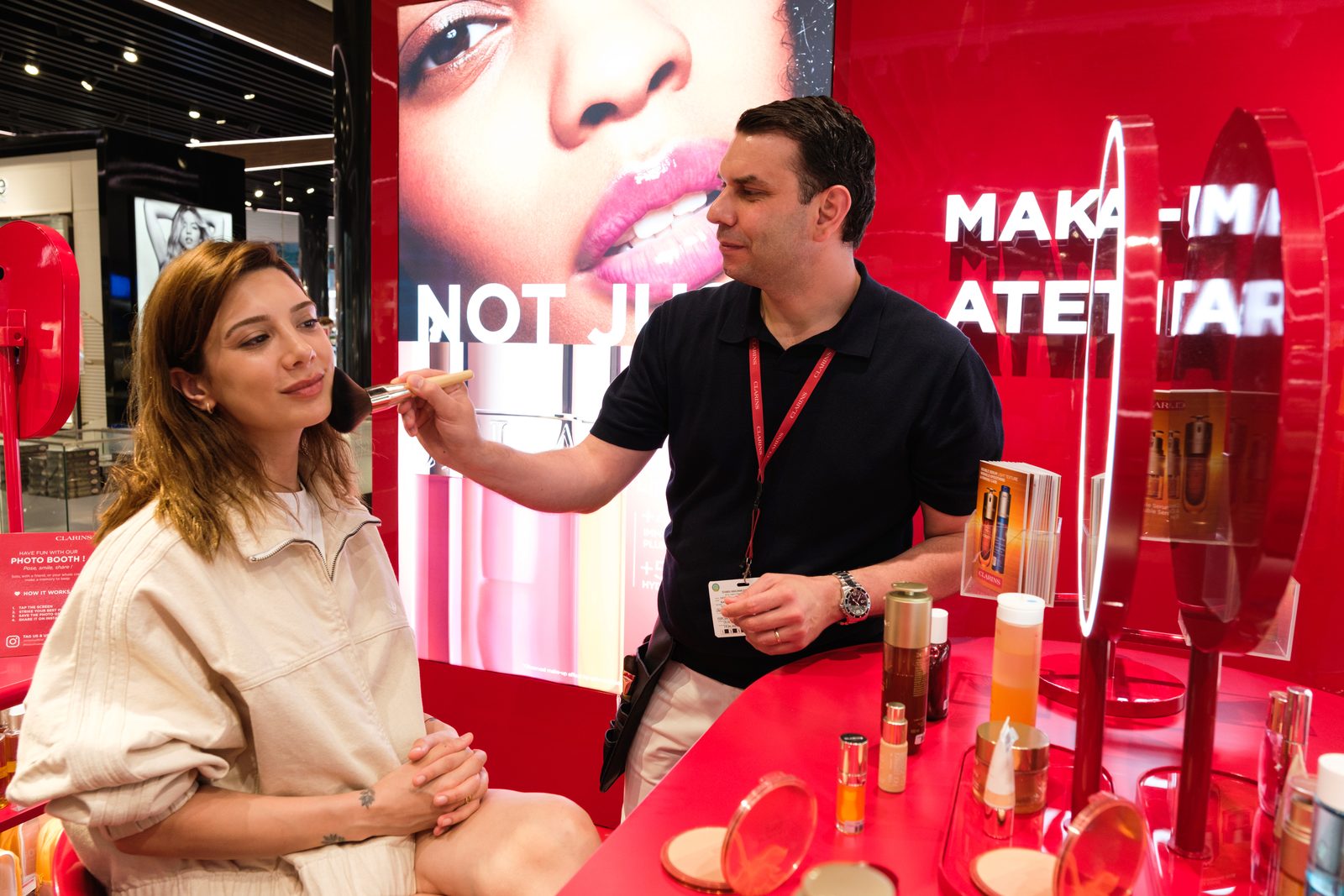 Makeup session at the Clarins Make-Up Atelier with the artist at work and the guest seated at the counter.
