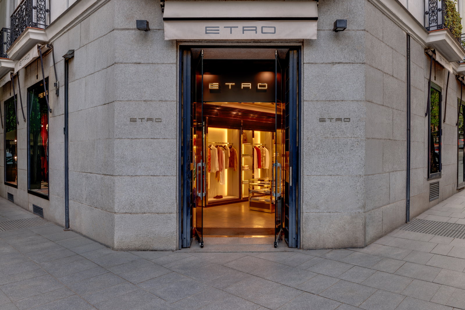 Fachada de piedra y entrada abierta de la boutique ETRO con luz cálida desde el interior.