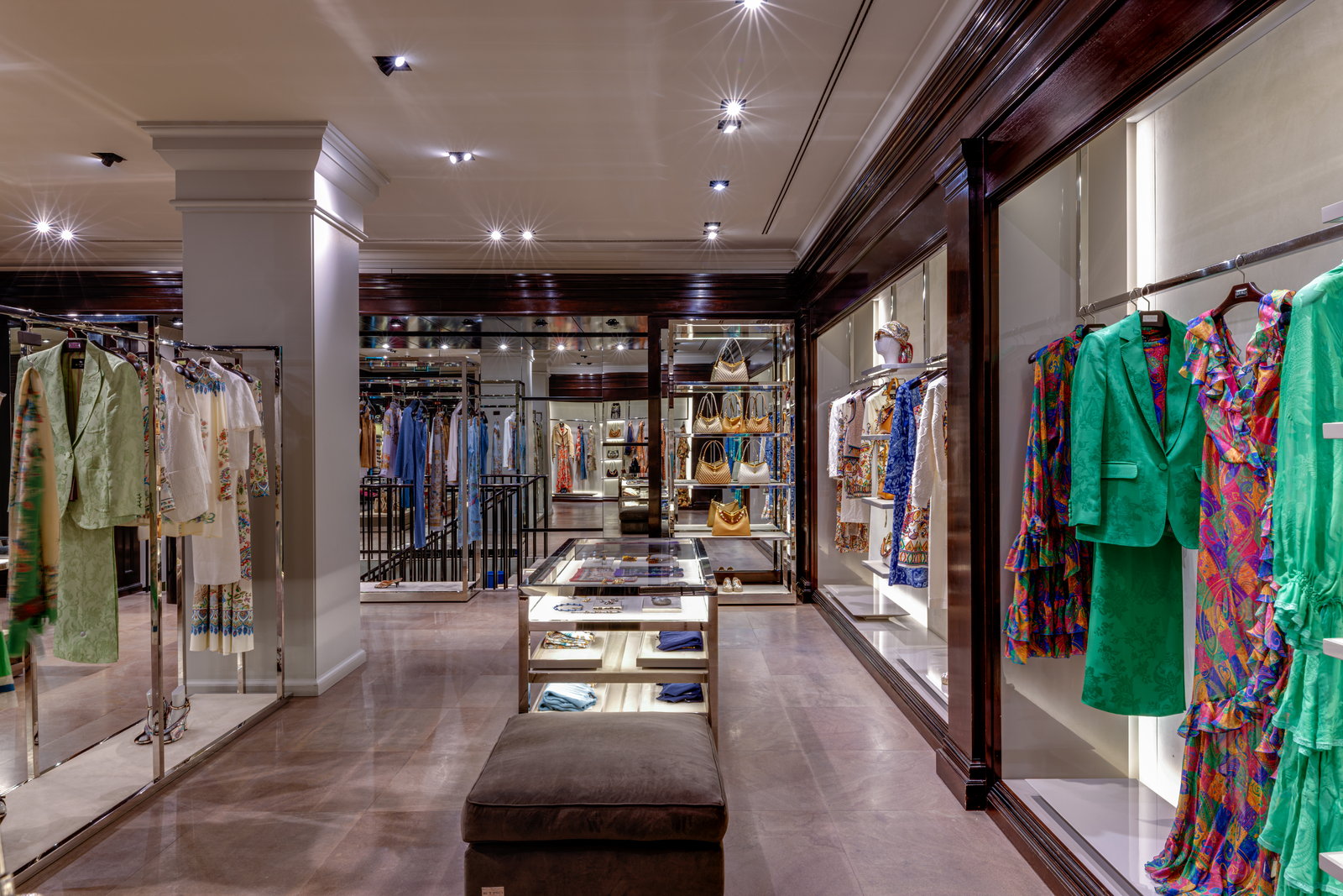 Perchas de ropa de mujer y vitrinas en la sala delantera de la boutique.
