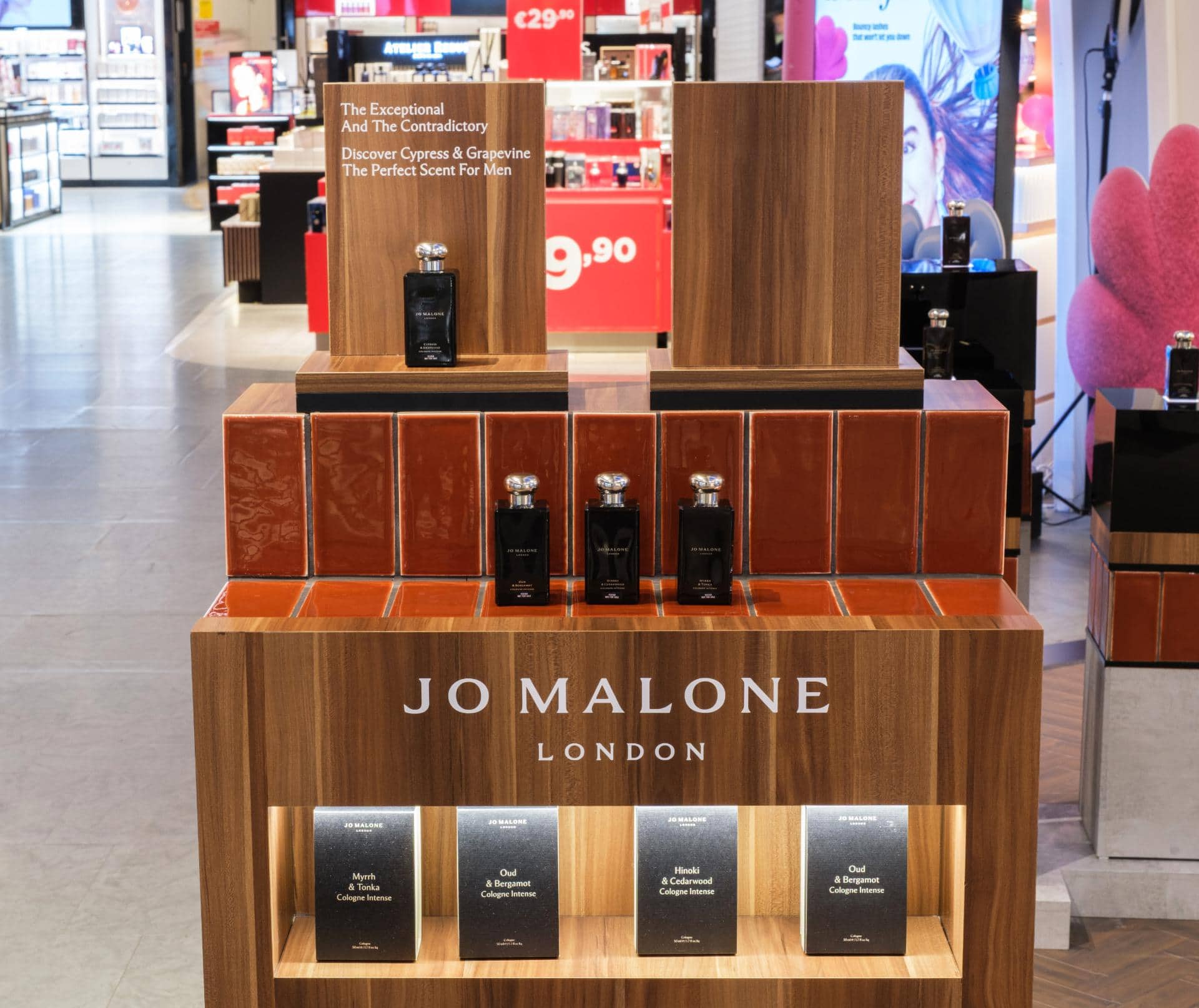 Elegant retail display of Jo Malone London perfumes with wooden shelving and product arrangement.