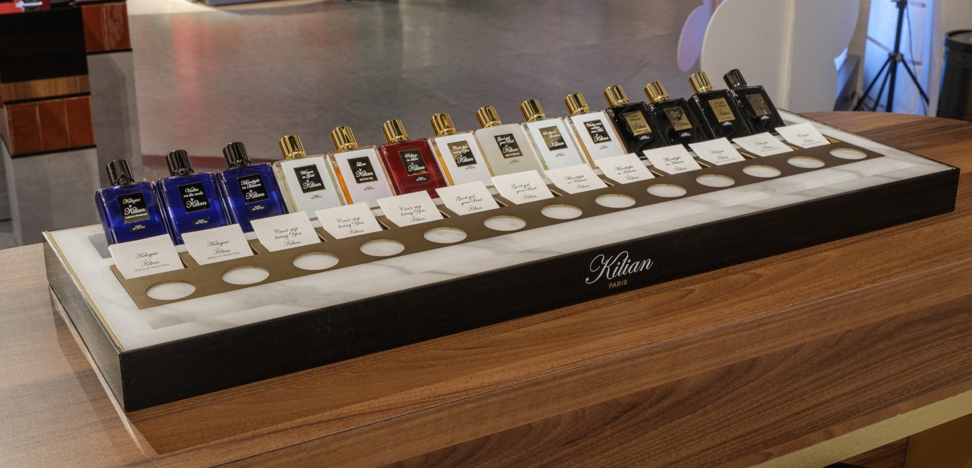 Kilian Paris fragrance bottles arranged along a timber counter in an airport duty free store.