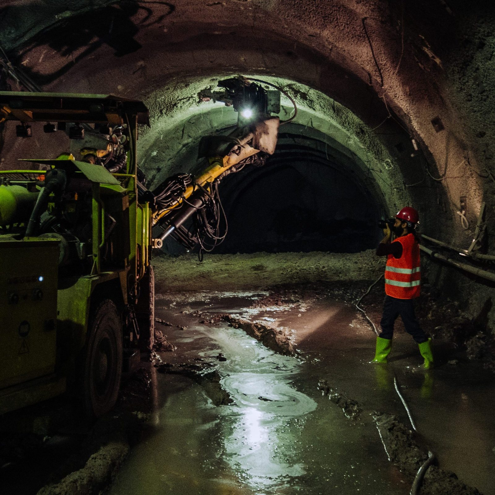 Professional photographer in full PPE, PRL trained, documenting an active metro construction site