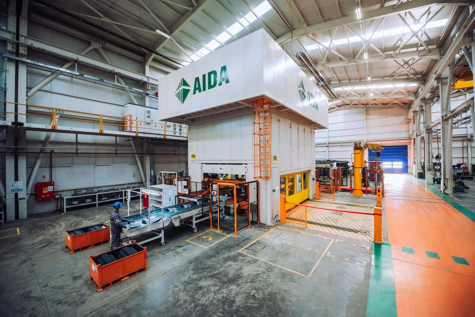 Press line inside a metal forming plant, heavy machinery and workers in protective equipment, Istanbul.