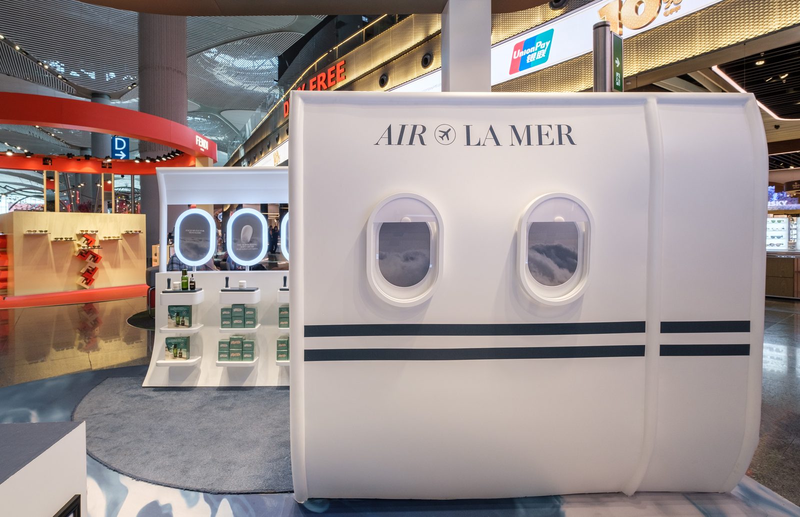 Air La Mer installation built as an aircraft cabin with porthole windows at Istanbul Airport.