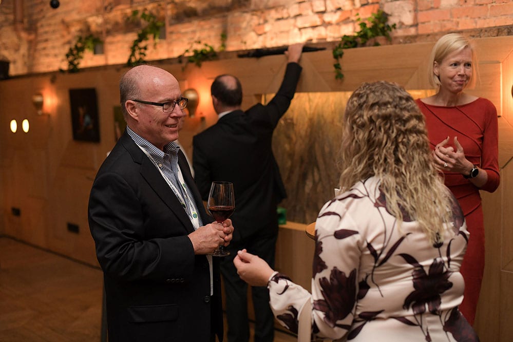 Guests in conversation at an evening networking reception.
