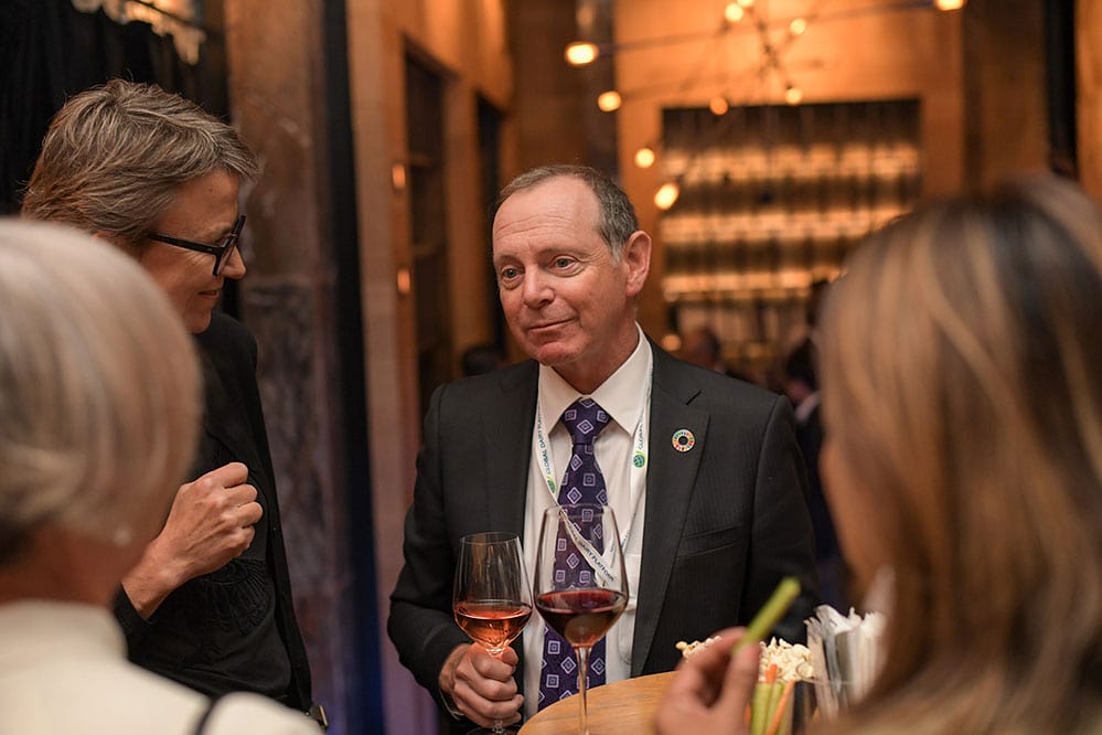 Delegates talking at a drinks reception in a warmly lit venue.