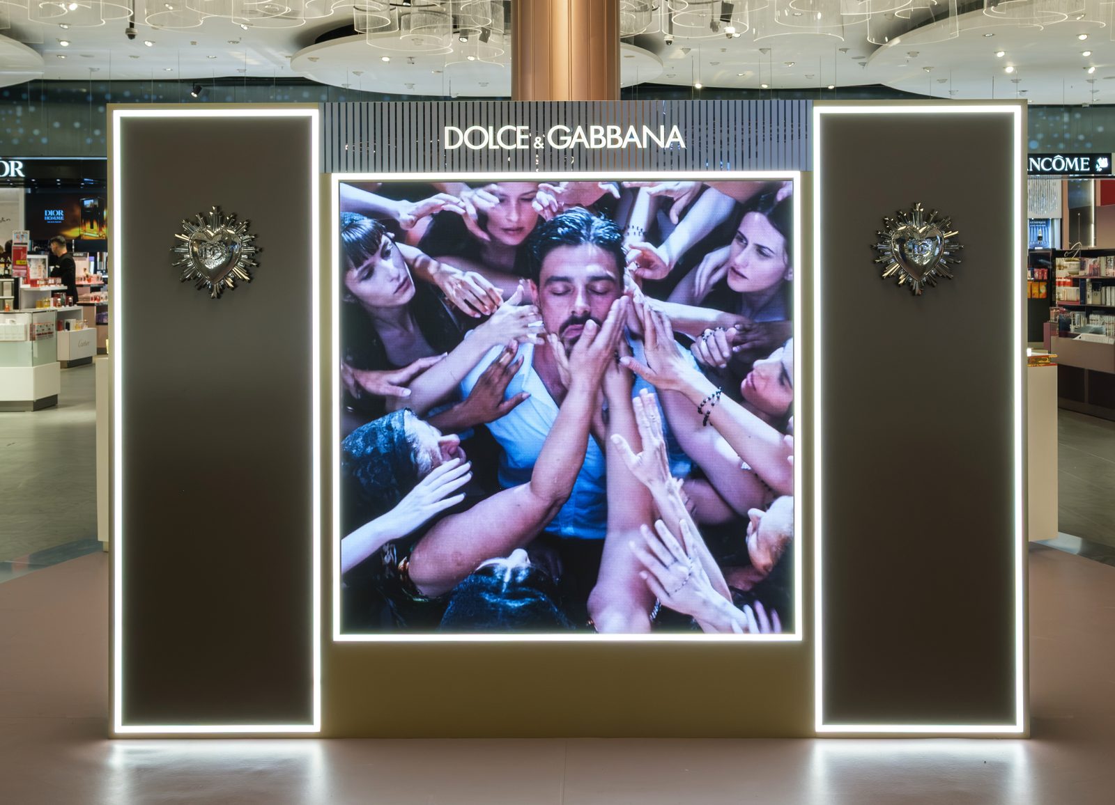 Dolce & Gabbana campaign light wall framed by two illuminated panels with sacred heart ornaments.