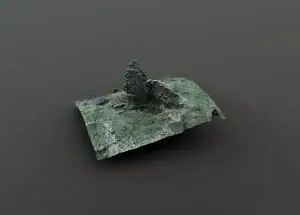 Remnants of an old stone structure covered in moss and lichen, situated on a flat surface with a dark background.