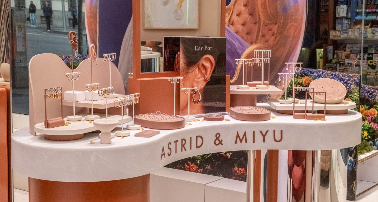 Elegant display of jewelry at Astrid & Miyu launch event in Madrid, showcasing necklaces, earrings, and rings on stylish stands with branding.