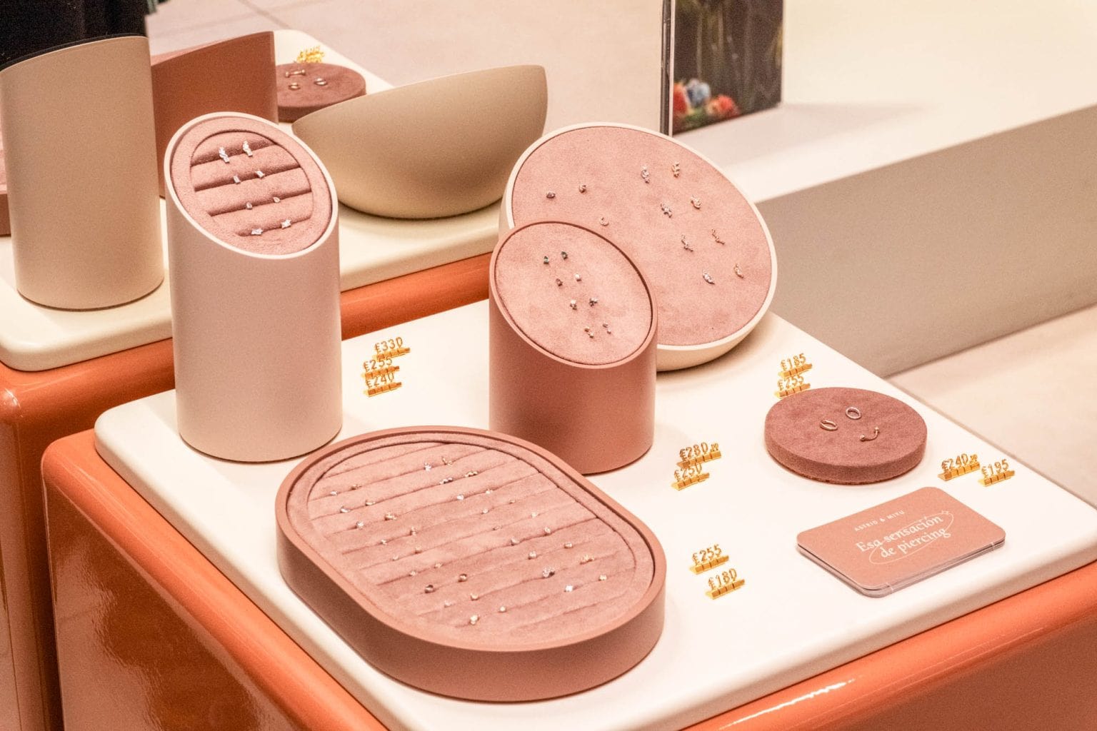 Close-up of minimalist skincare containers and promotional materials at Astrid & Miyu launch event in Madrid.